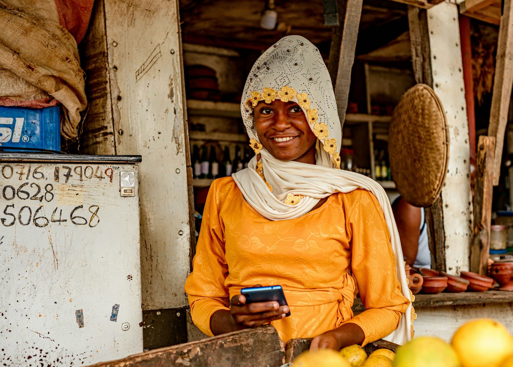 Mfanyabiashara wa Tanzania akitumia simu dukani